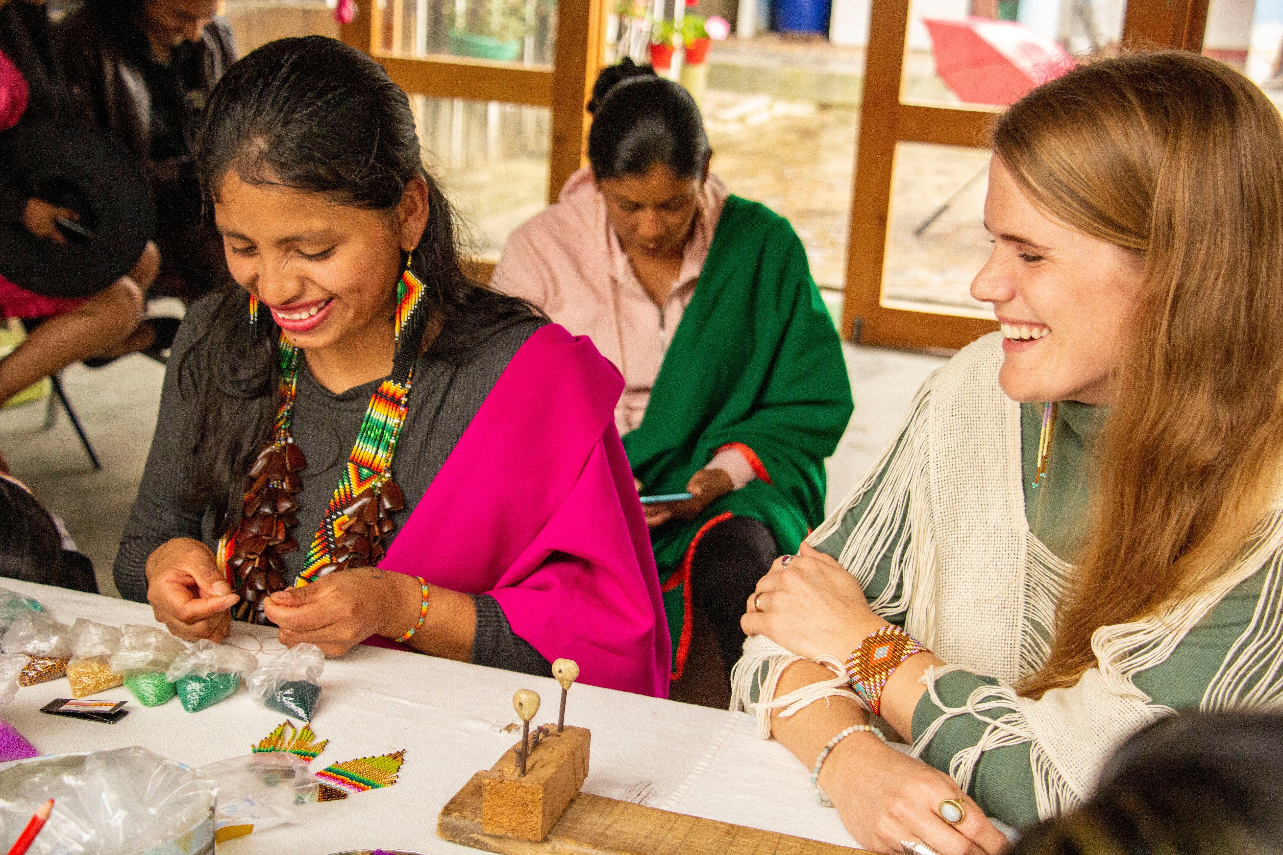 Inga Artisan and Wild You Handmade Founder sit at a table and smile as they talk.